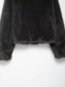 Detail of premium black faux fur coat showing smooth plush texture and sleek hemline finish