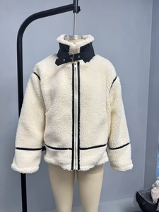 Detail of cream fleece jacket featuring black leather trim and buckled stand-up collar