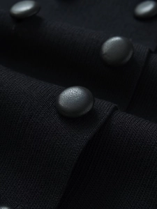 Macro shot of textured black leather buttons on a fine rib knit fabric cardigan detail
