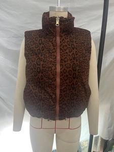 Close-up of brown leopard print puffer vest featuring a high collar and metal toggle detail