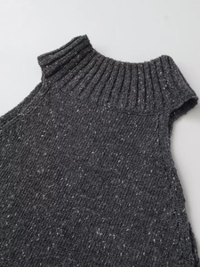 Close-up of dark grey high neck knit vest showing thick ribbed texture and marl finish