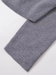 Close-up of gray knit cardigan featuring high-quality plain stitch and ribbed edge detail