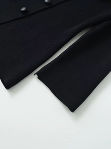 Detailed macro view of black knit fabric with premium round leather-textured buttons