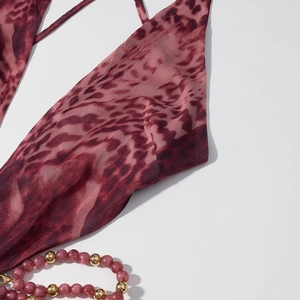 Détail d'une robe dos nu à imprimé léopard rose avec fines bretelles et bijoux