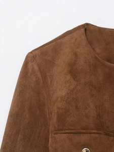 Dettaglio di un blazer in finta pelle scamosciata marrone con texture e bottone in metallo