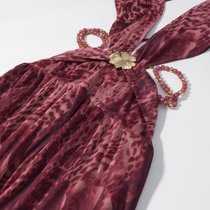 Détail d'une robe léopard rouge avec ornement floral doré et licou orné de perles fines