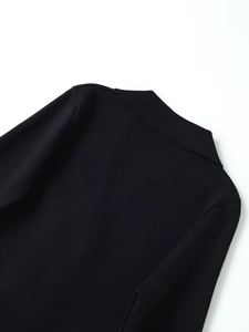 Close-up of black knit cardigan showing collar stitching and fine fabric texture