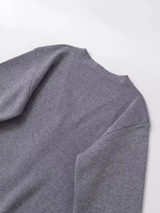 Detailed close-up of dark grey fine knit fabric texture and smooth neckline finish