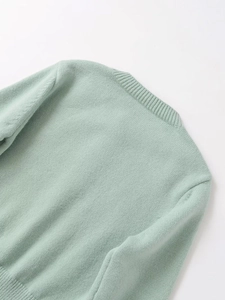 Detail of mint green rib-knit sweater showing collar texture and high-quality stitching