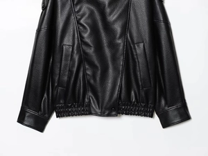 Détail d'une veste en similicuir noir avec ourlet élastique et texture grainée