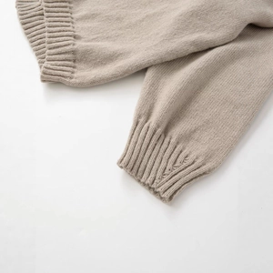 Minimalist beige knit sweater with ribbed cuffs and high-quality fine texture