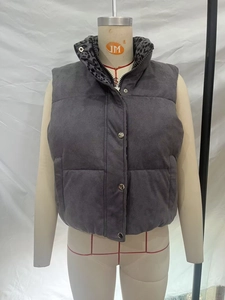 Detail of gray padded vest with stand collar featuring leopard print lining and snap buttons