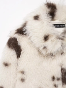 Close-up of the plush faux fur collar featuring a stylish black and white cow print texture