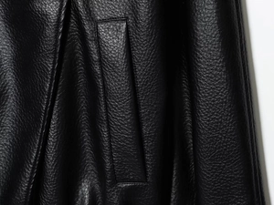 Détail de la poche latérale et texture grainée sur une veste en similicuir noir