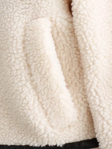 Detail of sherpa fleece jacket with high-contrast black leather trim and pocket stitching