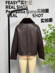 Detail view of the back of a dark brown reversible faux leather jacket with faux fur trim