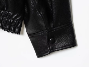 Vue détaillée de la veste en similicuir grainé avec ourlet élastique et boutons noirs