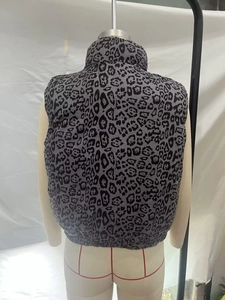 Detailed back view of a reversible leopard print puffer vest with a high stand collar