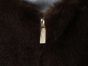 Detail der Premium-Kunstfellstruktur mit Hochglanz-Finish und goldenem Metall-Reißverschluss