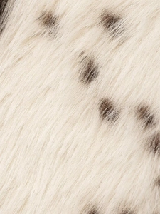 Macro shot of faux fur fabric texture featuring fluffy black and white animal print spots