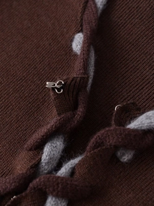 Détail de la maille marron foncé avec laçage croisé gris et fermoir métallique