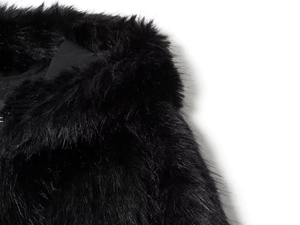 Close-up of premium black faux fur texture with silky gloss on a hooded jacket detail