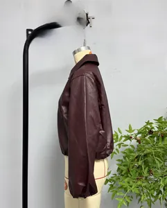 Detail view of burgundy faux leather jacket featuring elastic cuffs and turn-down collar