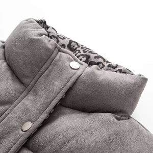 Detail of grey puffer vest collar with leopard print lining and silver metal snap button