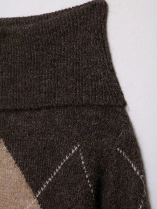Detail of argyle pattern knitwear featuring brown and khaki rib-knit wool blend fabric