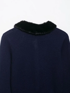 Detail view of navy knit cardigan with thick black faux fur collar on the back shoulders