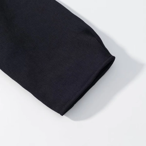 Gros plan sur le tissu sergé noir et les coutures nettes d'un blazer court pour femme
