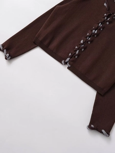 Vue détaillée d'un pull en maille côtelée marron foncé avec laçage décoratif en corde grise