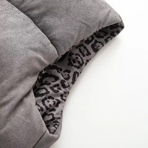 Detail of gray matte fabric and leopard print lining on reversible padded vest