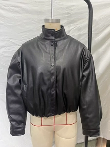 Detail view of the high neck black faux leather bomber jacket with snap button closure