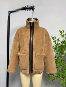 Dettaglio di giacca in pile marrone con zip, collo alto e ampie tasche anteriori