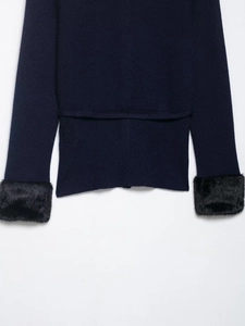 Detail of navy knit sweater featuring luxurious black faux fur trim on the sleeve cuffs