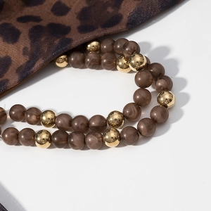 Vue détaillée de perles d'agate brune et dorées sur tissu à motif léopard