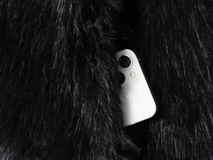 Detail of faux fox fur texture featuring a functional side pocket with a smartphone