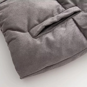Detail of grey quilted vest fabric showing fine texture and reinforced pocket stitching