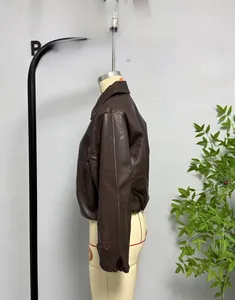 Detail view of a dark brown faux leather jacket featuring a classic lapel and side pockets