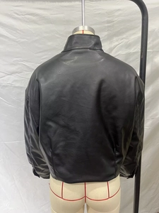 Back view of a black faux leather bomber jacket with high collar and padded texture