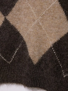 Close-up of the plush knit fabric with a classic brown and oat diamond pattern