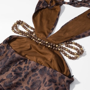 Détail de la robe léopard avec chaînes de perles et finitions en métal doré