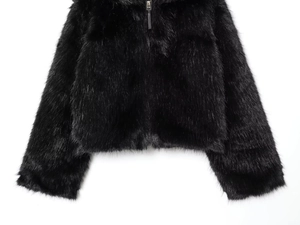 Detail of soft black faux fur jacket texture and smooth metal zipper closure close-up