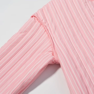 Detailed macro view of sleeve stitching on pink and white vertical striped cotton shirt