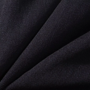 Vue macro détaillée de la texture du tissu sergé noir pour un blazer court à boutons dorés