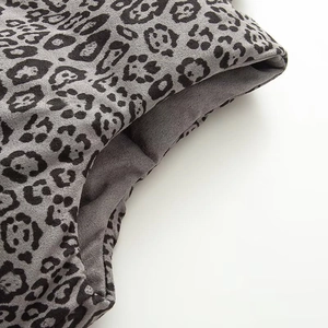 Detailed macro view of the double-sided leopard print fabric with thick quilted stitching