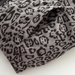 Detail of leopard print puffer vest featuring side metal zipper and diagonal pocket