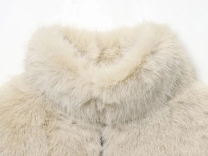 Gros plan du col en fourrure synthétique beige montrant une texture dense et douce