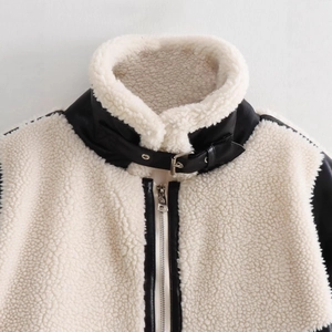 Women's patchwork faux shearling biker jacket with black leather trim and metal buckles